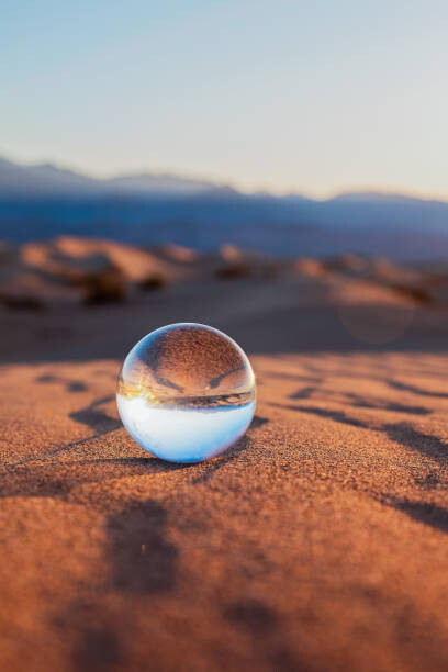 Umělecká fotografie Glass Sphere on Desert Sand