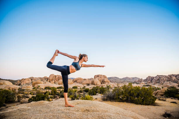 Konstfotografering Hispanic woman performing yoga in desert