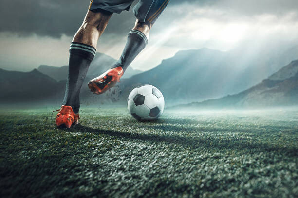 Fotografi Legs of soccer player kicking the ball
