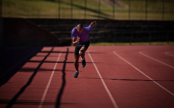 Konstfotografering Male runner sprinting at stadium