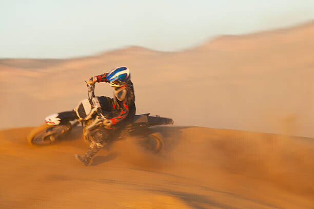 Художествена фотография Man motocross riding in desert terrain