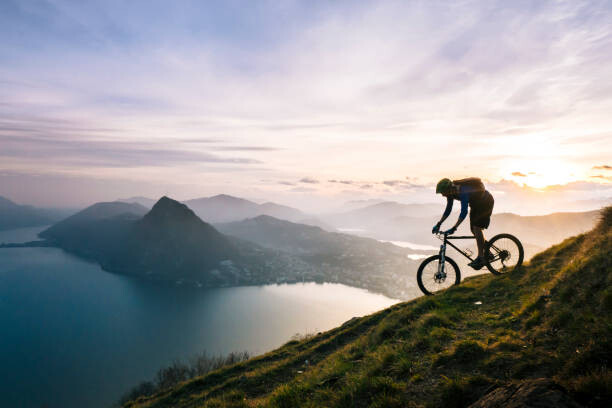 Umělecká fotografie Mountain biker descends steep mountain slope