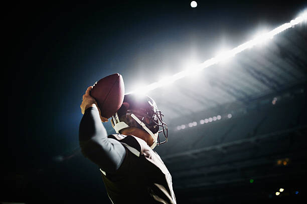 Fotografi Quarterback preparing to throw pass at night
