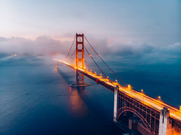 Fotografía artística Red Golden Gate Bridge under a foggy sky (Dusk)