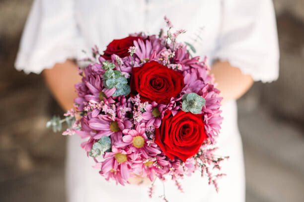 Umělecká fotografie Red roses and pink flowers in a bridal bouquet