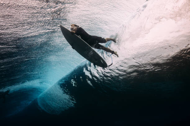 Художествена фотография Surfer dives beneath a wave