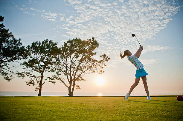 Umělecká fotografie Teen girl makes a powerful drive on a golf course