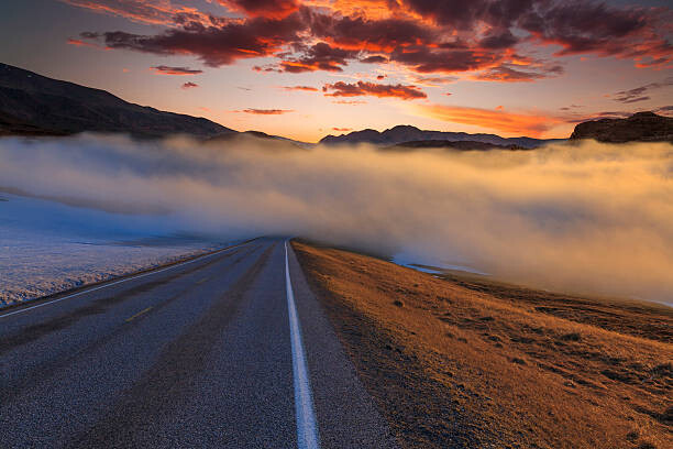 Fotografia The road in the fog at sunset. Norway