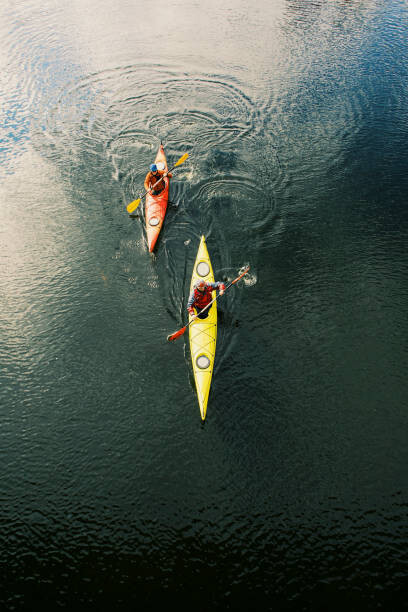 Umetniška fotografija Two men are kayaking along the river.