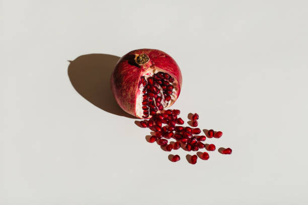 Umetniška fotografija ut pomegranate on a white background.