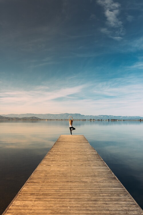 Umetniška fotografija Woman doing yoga in the harbor