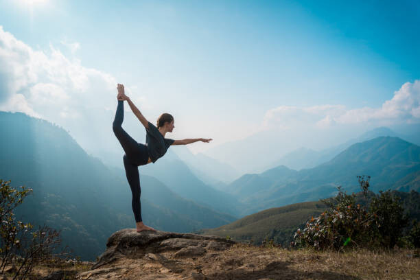 Konstfotografering Woman training yoga, mountains on background