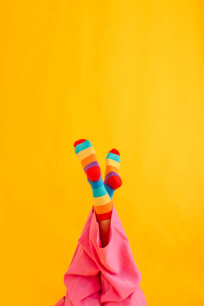 Umelecká fotografie Woman wearing colorful socks against yellow