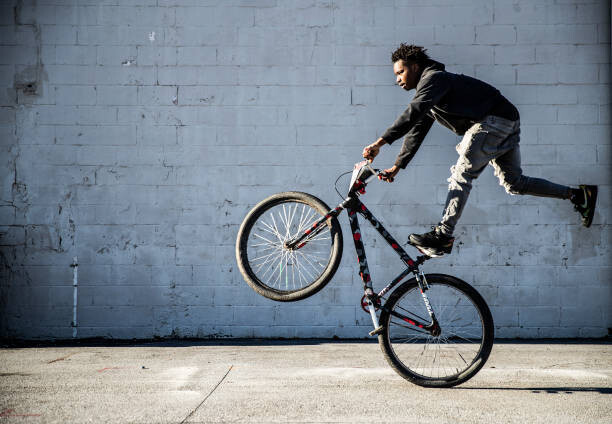 Fotografia artystyczna Young male BMX rider performing wheelie