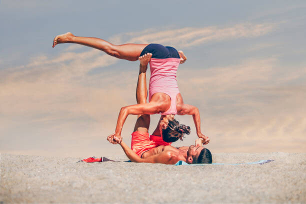 Umelecká fotografie Young sporty couple practicing acroyoga exercises