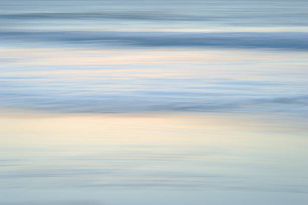 Two women doing yoga on the beach at sunrise