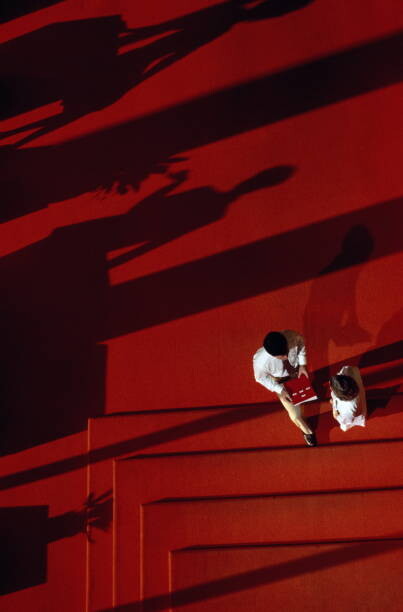 Canvas Print Executives conferring in lobby, shadows and stairs