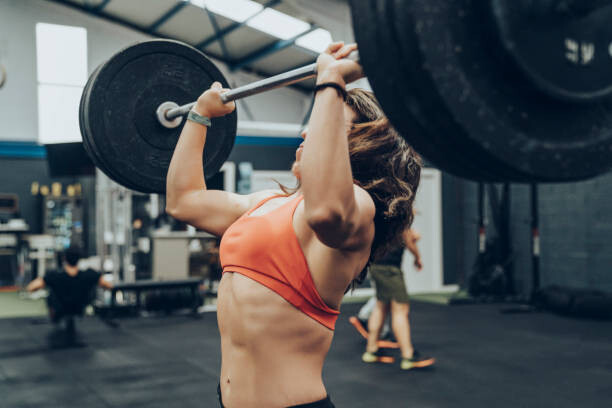 Canvas Print Unknown strong woman exercising with a bar.