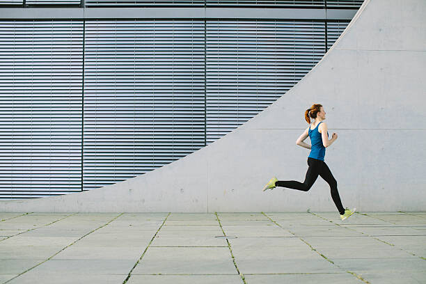 Schilderij op canvas Woman running in front of a building