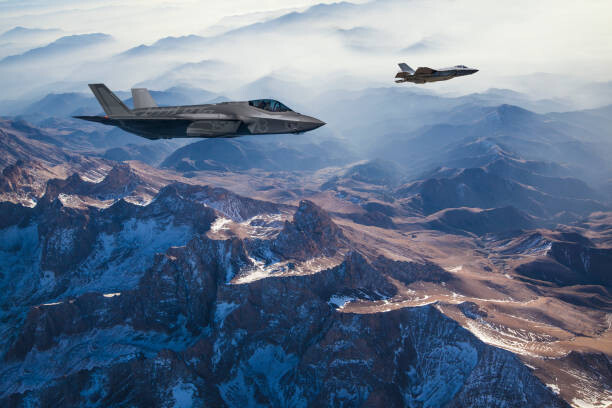 Samolepka Fighter Jets flying over mountains at dusk
