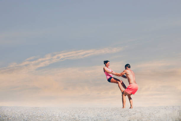 Behang Young sporty couple practicing acroyoga exercises