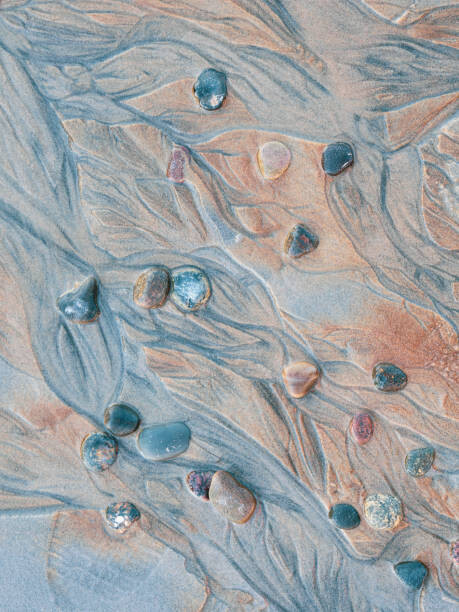 Fototapete Close-up of pebbles and textured sand
