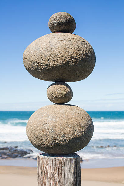 Fototapete Tower of rocks balancing on a wooden pole