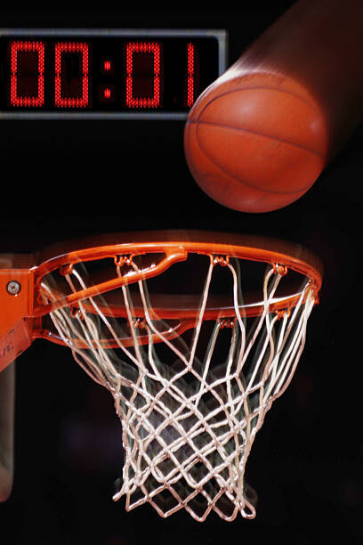 Fototapeta Basketball falling into basket (blurred motion)