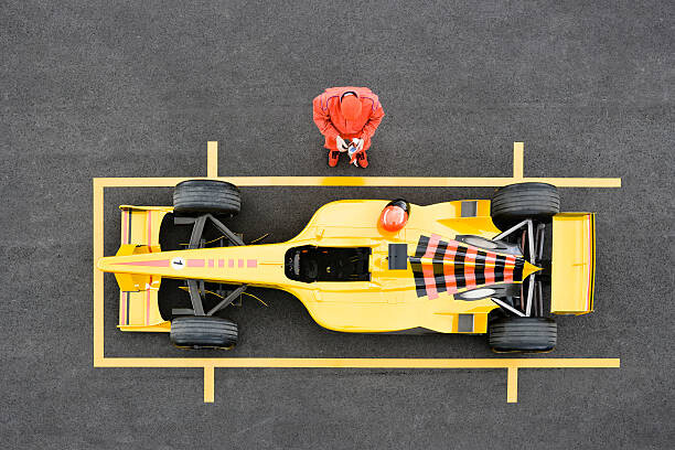 Fototapeta Racecar Driver Standing by Racecar Adjusting