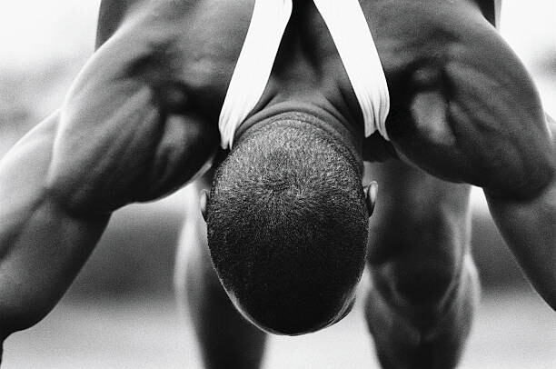 Fototapeta Runner bending forward, stretching