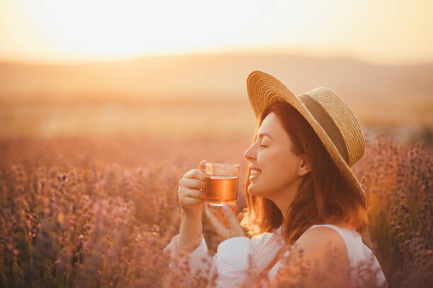 Fototapeta Young happy woman drinking herbal tea,