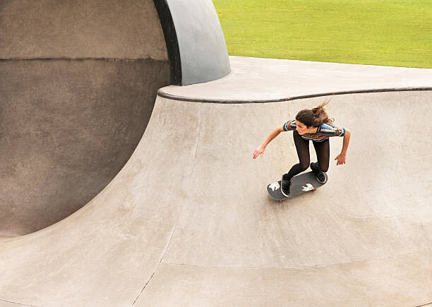 Fototapeta Young woman skateboarding