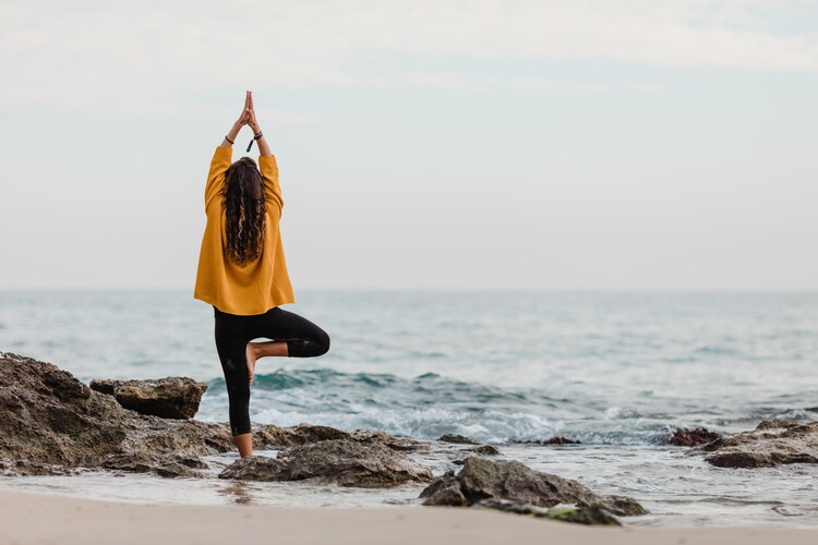 Kunstfotografier practicing yoga at beach