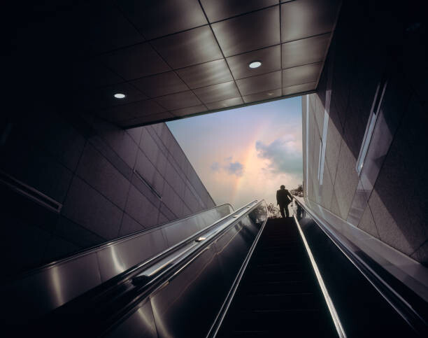 Bild auf Leinwand Businessman on escalator moving towards sky