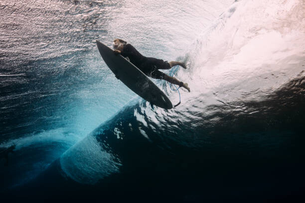Bilde på lerret Surfer dives beneath a wave