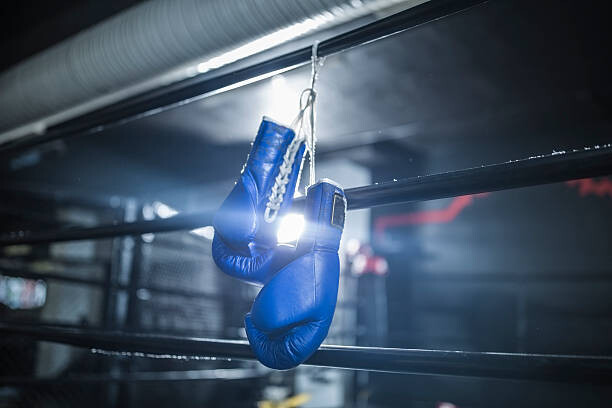 Obraz na plátně Boxing gloves hanging in boxing ring