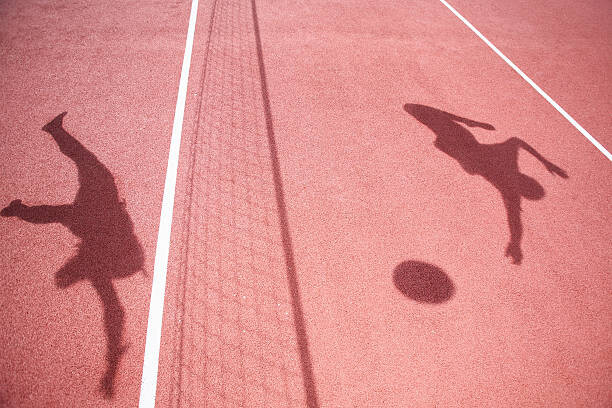 Obraz na plátně Shadows of athletes playing volleyball