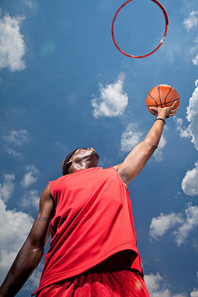 Obraz na plátně Basketball player shooting basket, view from below