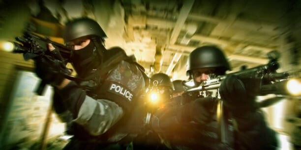 Obraz na plátně Police on the move aiming rifles