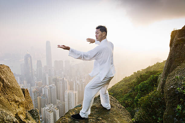 Cuadro en lienzo Man practicing Tai Chi infront of skyline