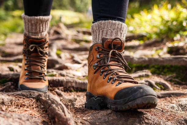 Plagát Leather hiking boots walking on mountain trail