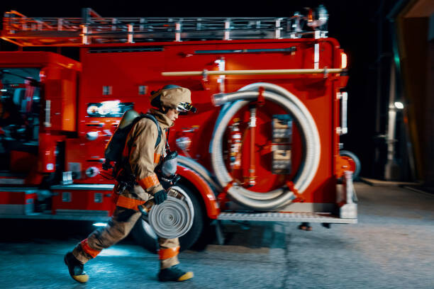 Plakat Firefighter running with a hose next