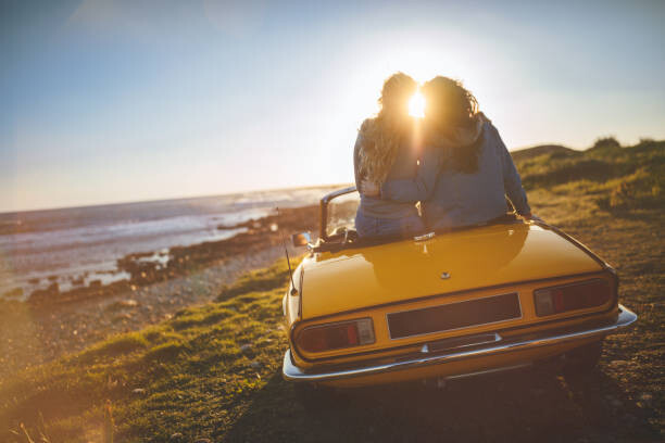 Plakat Women with convertible car relaxing at