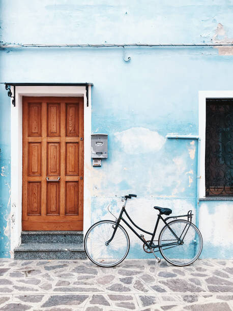 Plakát Bicycle parked against blue wall in a village