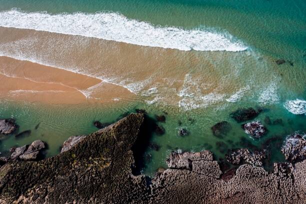 Plakát Aerial view, water lapping rocky coast, Portugal