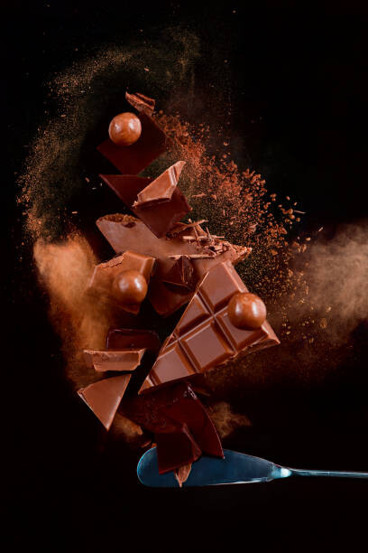Plakát Broken chocolate pieces balancing on a