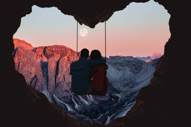 Plakát Couple on swing contemplating the mountains