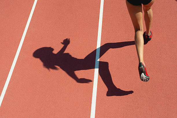 Plakát Female athlete running on track, low