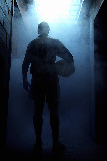 Plakát Football player entering steam room, rear view