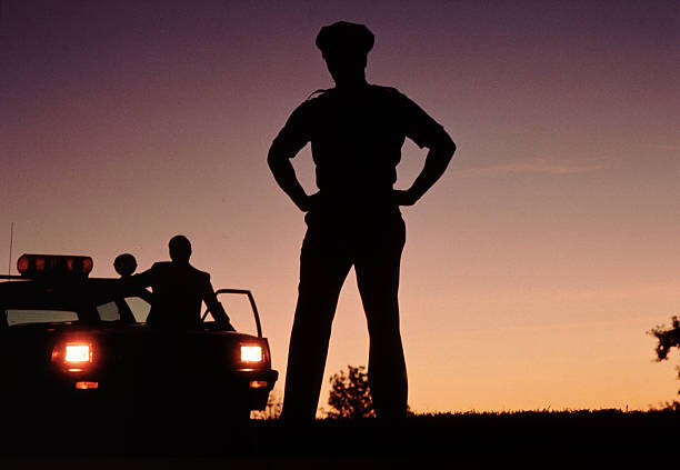 Plakát Silhouette of policemen with police car